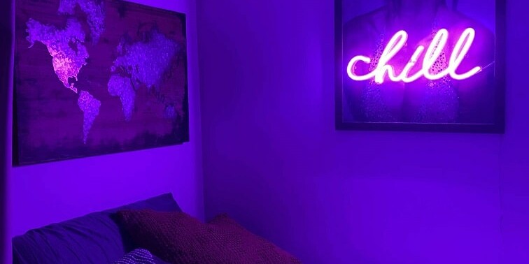 purple neon sign hanging in bedroom