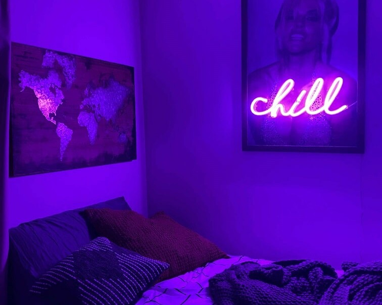 purple neon sign hanging in bedroom