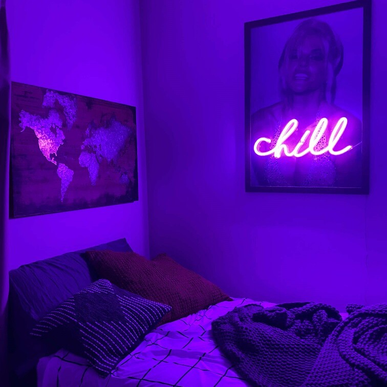 purple neon sign hanging in bedroom