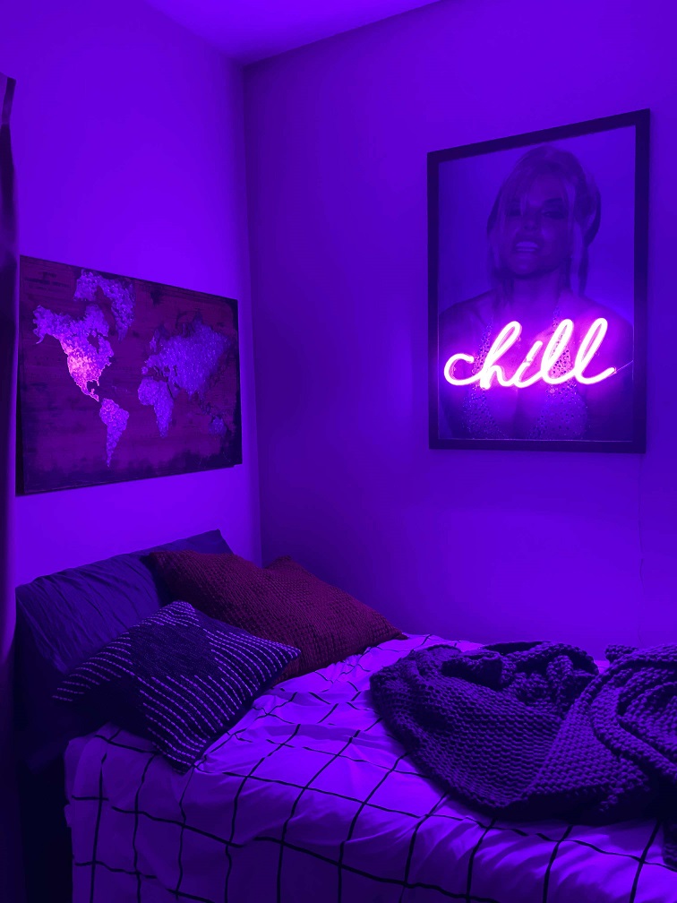 purple neon sign hanging in bedroom