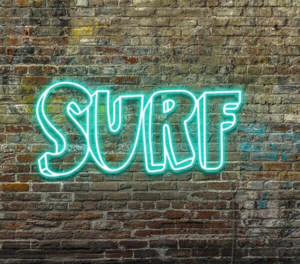 A personalized neon sign of the word 'surf' on a brick wall