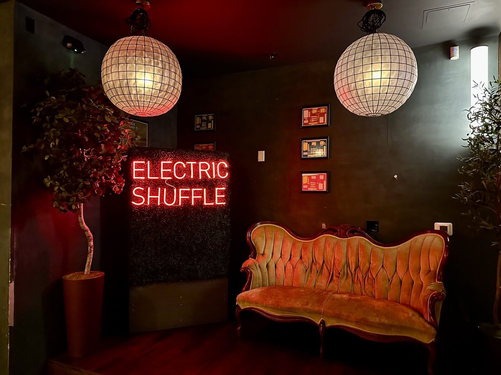Electric Shuffle Dallas led neon sign on greenwall