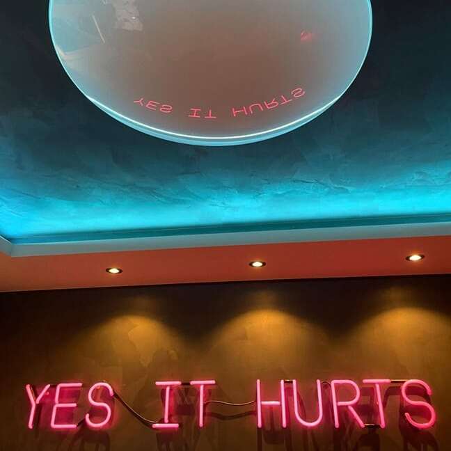 vintage glass neon sign in red color for tattoo shop