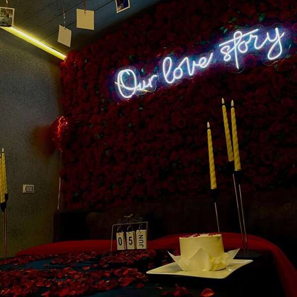 white custom neon sign on flower wall for anniversary