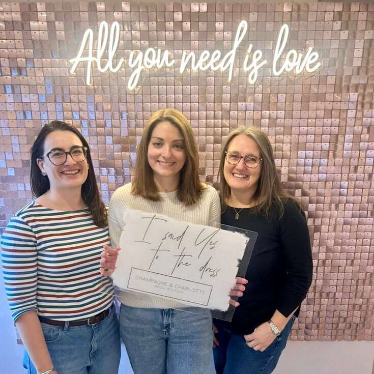 All You Need Is Love neon sign above a bridal shop celebration