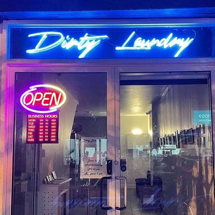 Blue letters laundromat neon sign with a neon Open sign