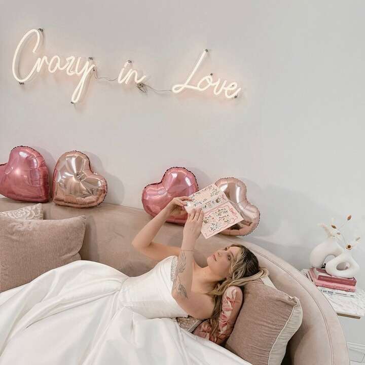 Crazy in Love neon sign above a bride on a bridal boutique sofa