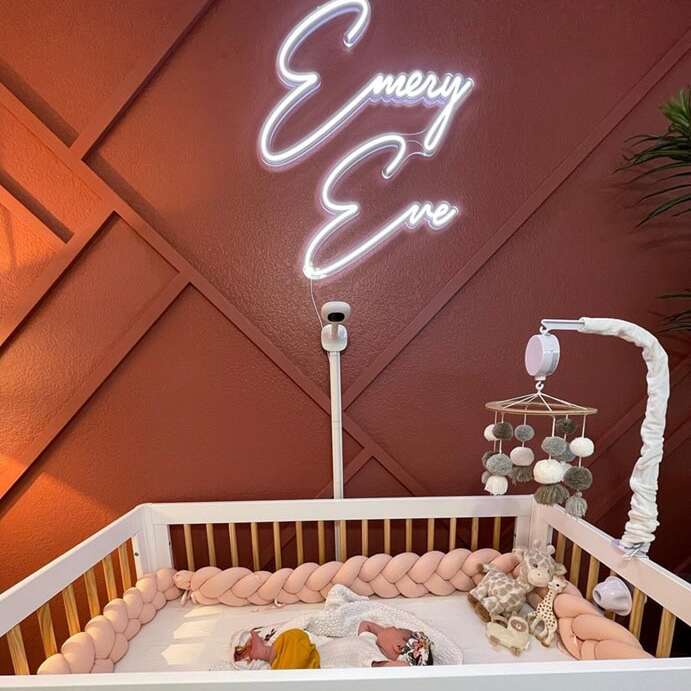 Custom neon sign for a nursery with white script name lettering