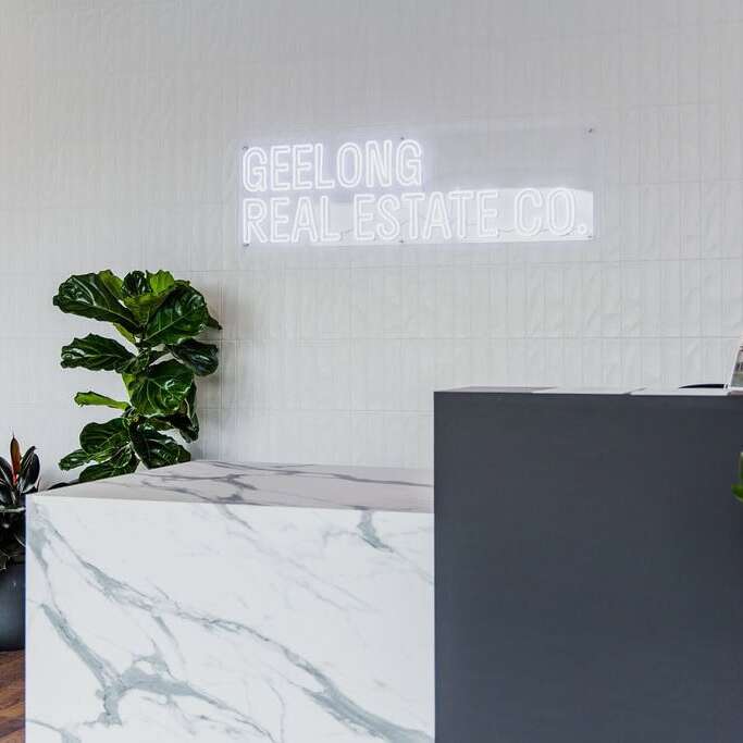 Custom white neon logo sign for a real estate office