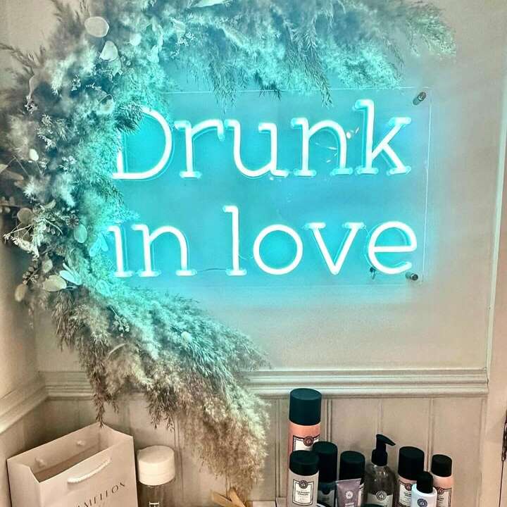 Drunk in Love neon sign surrounded by flowers in a bridal boutique