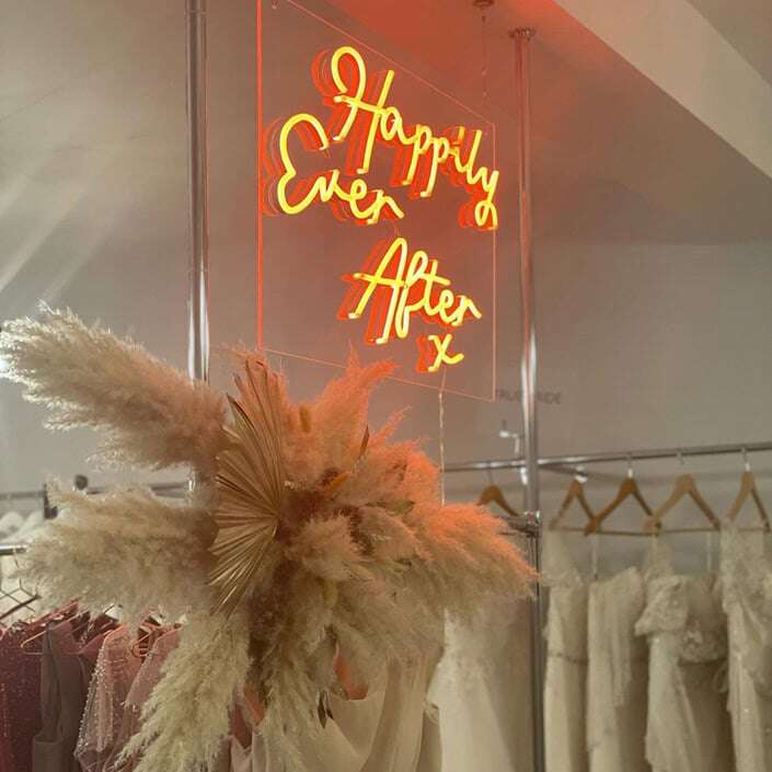 Happily Ever After neon sign with pampas grass in a bridal boutique
