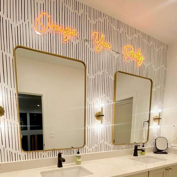 Orange You Pretty neon sign above double bathroom mirrors