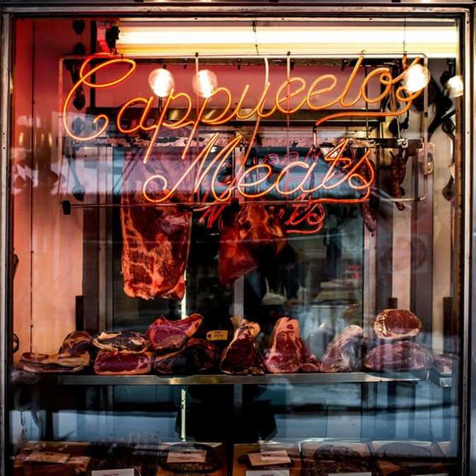 Orange script butcher shop neon sign for a display window