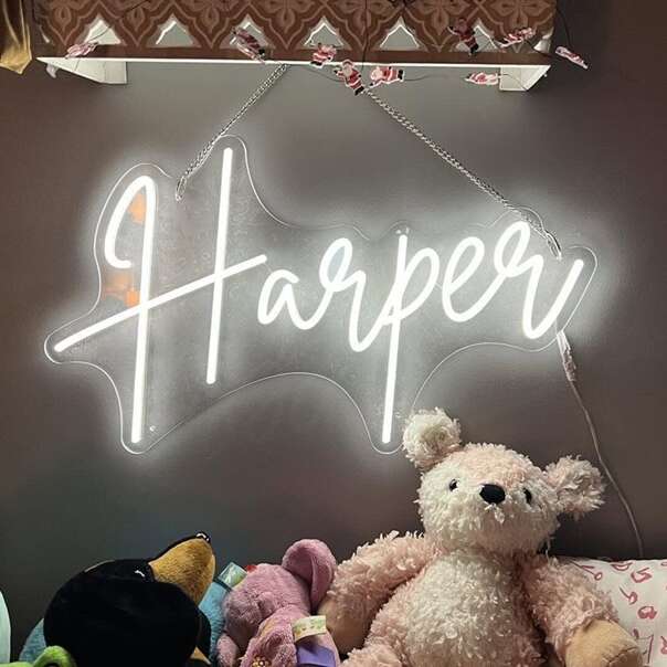 Personalized baby name neon sign in white script for a nursery