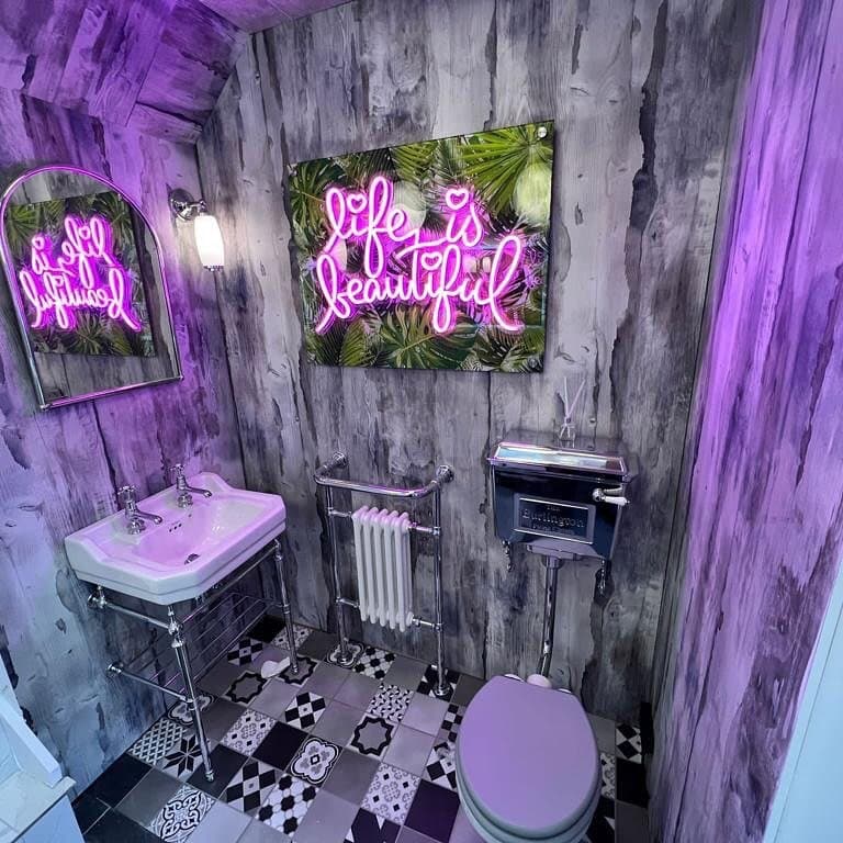 Pink Life Is Beautiful neon sign in a patterned powder room
