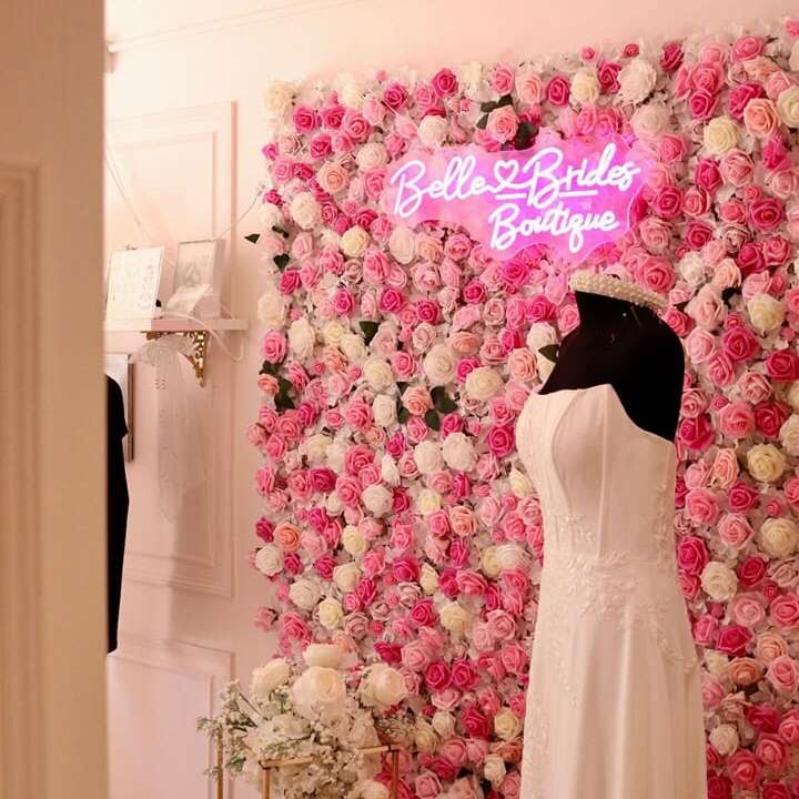 Pink bridal boutique neon logo sign on a floral photo backdrop