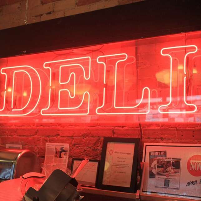 Red real glass neon sign for a deli in bold block lettering