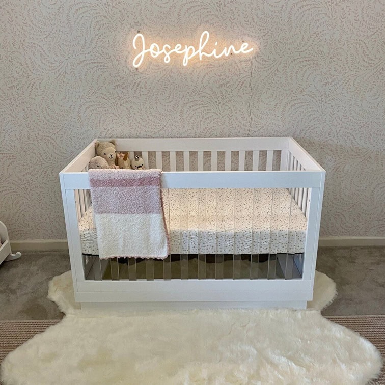 Warm white baby name neon sign for a classic nursery