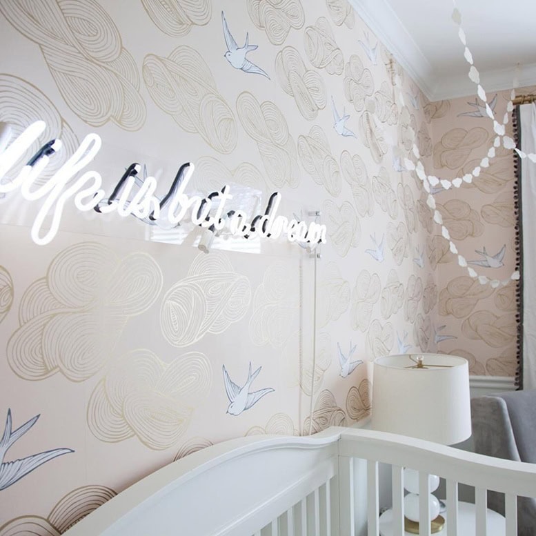 White glass neon quote sign for a nursery with floral wallpaper