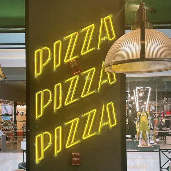 Yellow Pizza led neon sign on a pizzeria wall