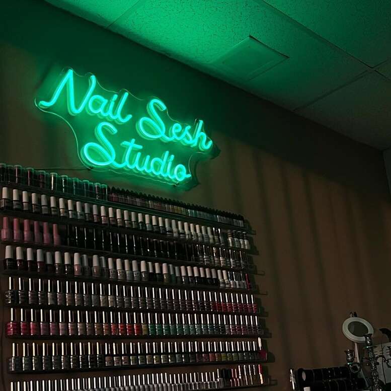 green nail studio neon sign displayed near the salon entrance