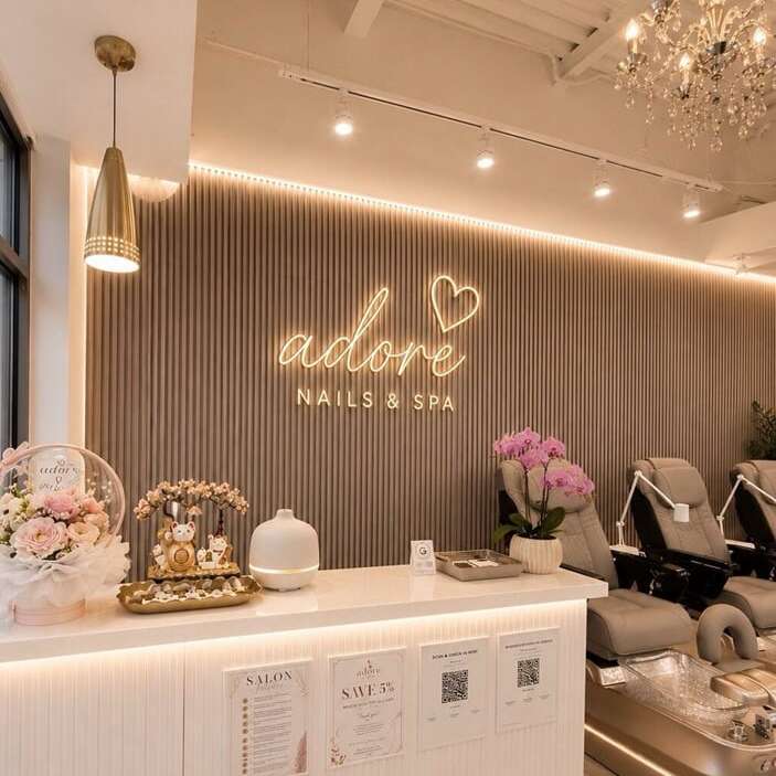 soft white neon sign above the reception desk in a nail salon